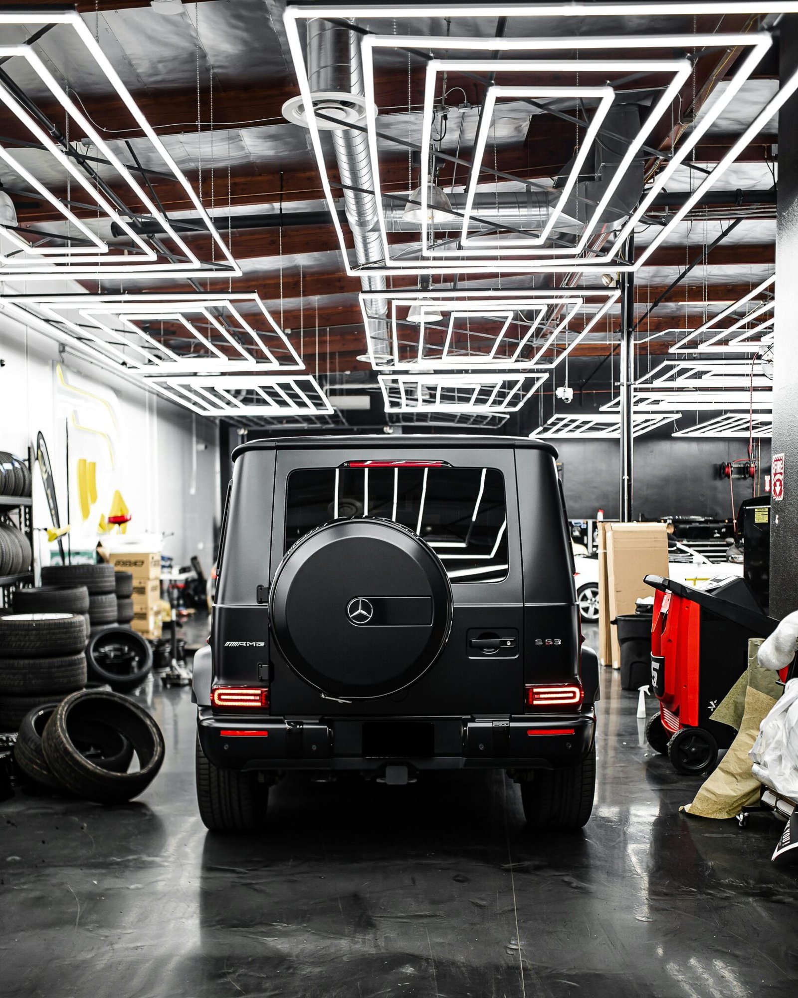 Stylish Mercedes-Benz G-Class SUV parked in a high-tech garage with geometric lighting.