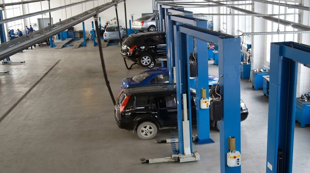 Vehicles on lifts inside an automotive workshop.