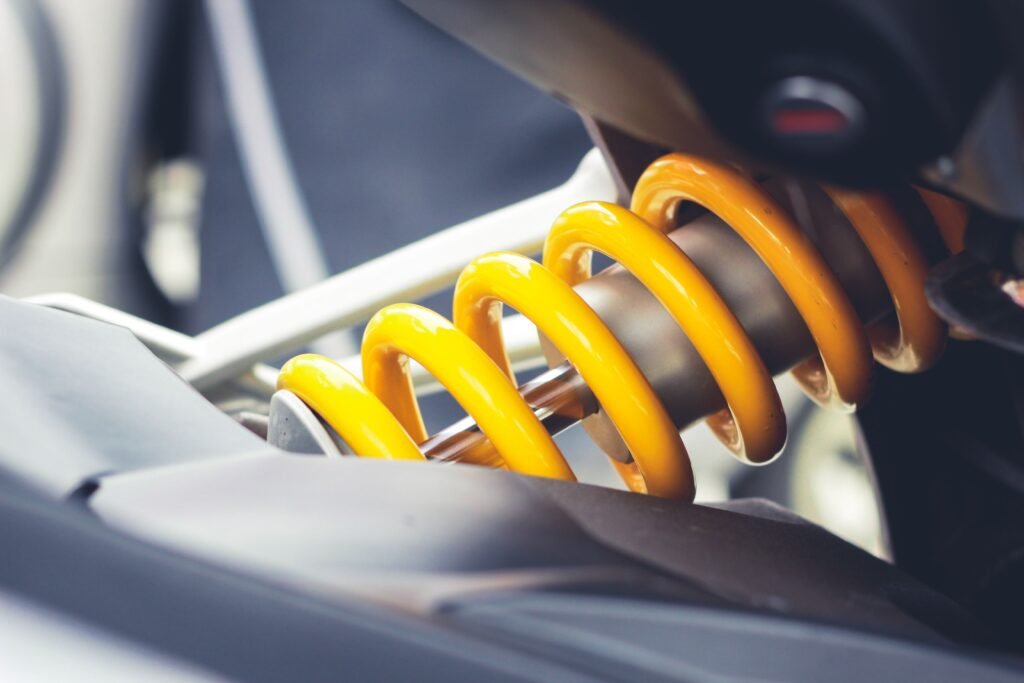 electric-vehicle-service-in-dubai.Close-up of a vibrant yellow coil spring, showcasing mechanical engineering details.