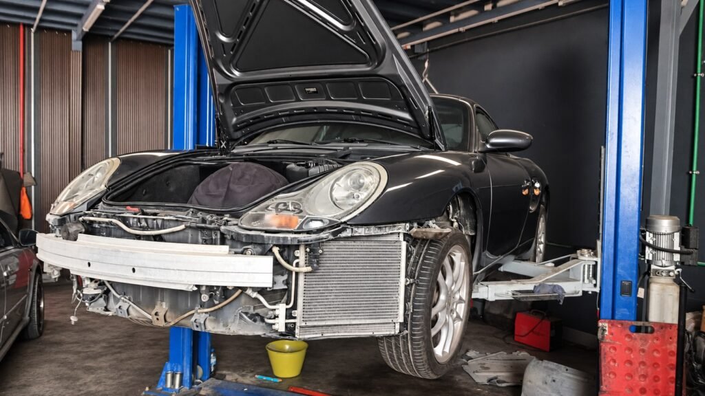 Clean Porsche 911 on a workshop lift with bonnet open and front bumper removed in Al Quoz, Dubai